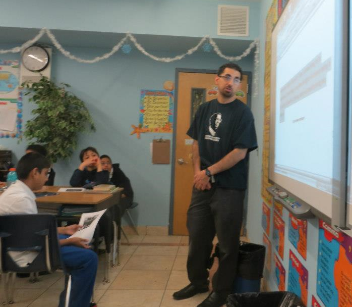 Ayman teaching about Malcolm X in a classroom